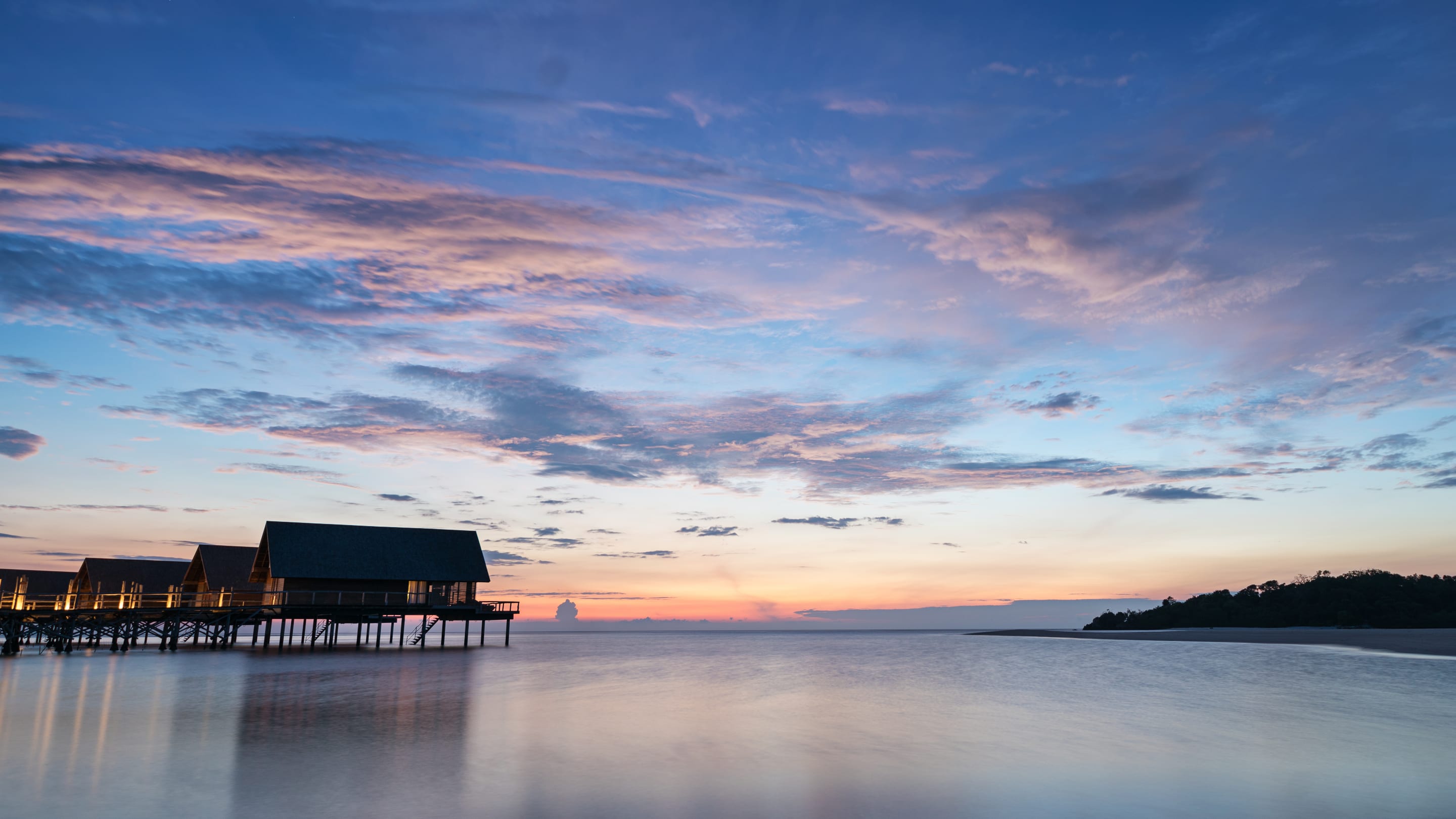 The overwater suites at dusk, long-exposure water